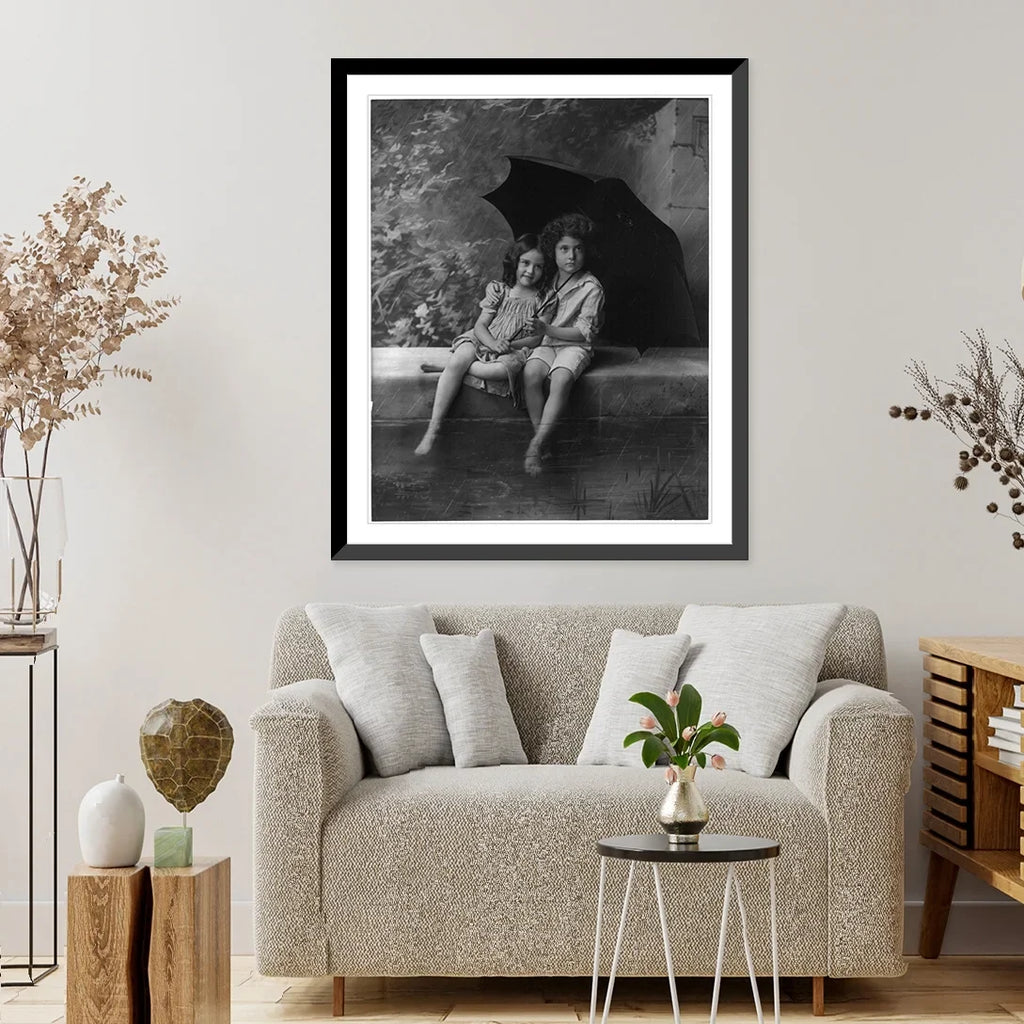 Historic Framed Print, [2 children on fountain wall, under umbrella in rain], 17-7/8" x 21-7/8"